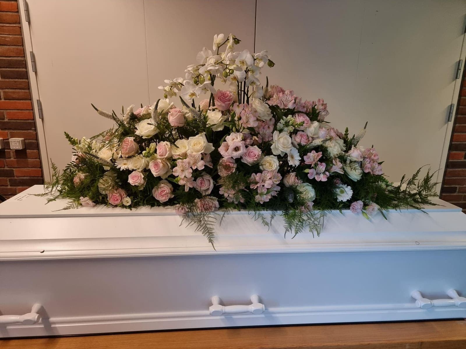 Kistepynt „Med hvide orkideer og lyserød og hvide roser mm.“ fra Miss Liss Blomster
