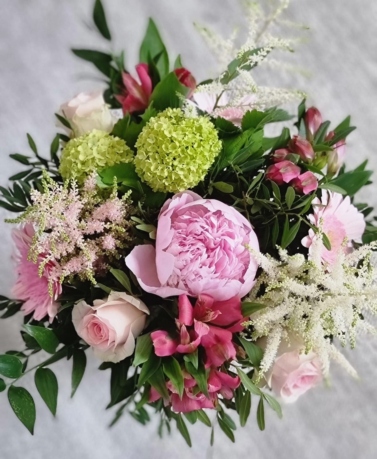 Buket med lyserød pæon, roser, snebolle, astilbe og alstroemeria