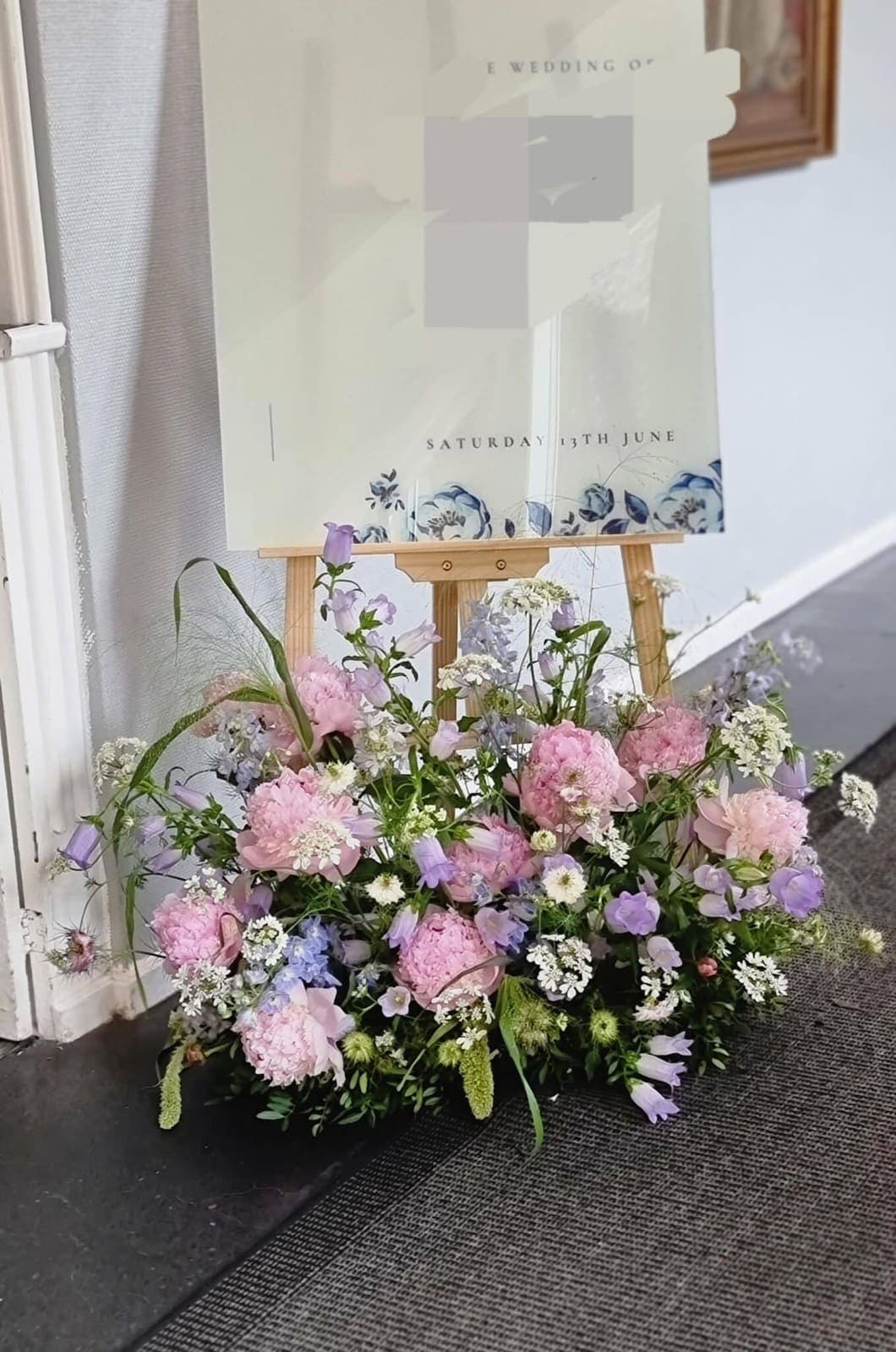 Blomsterarrangement ved velkomstskilt til fest