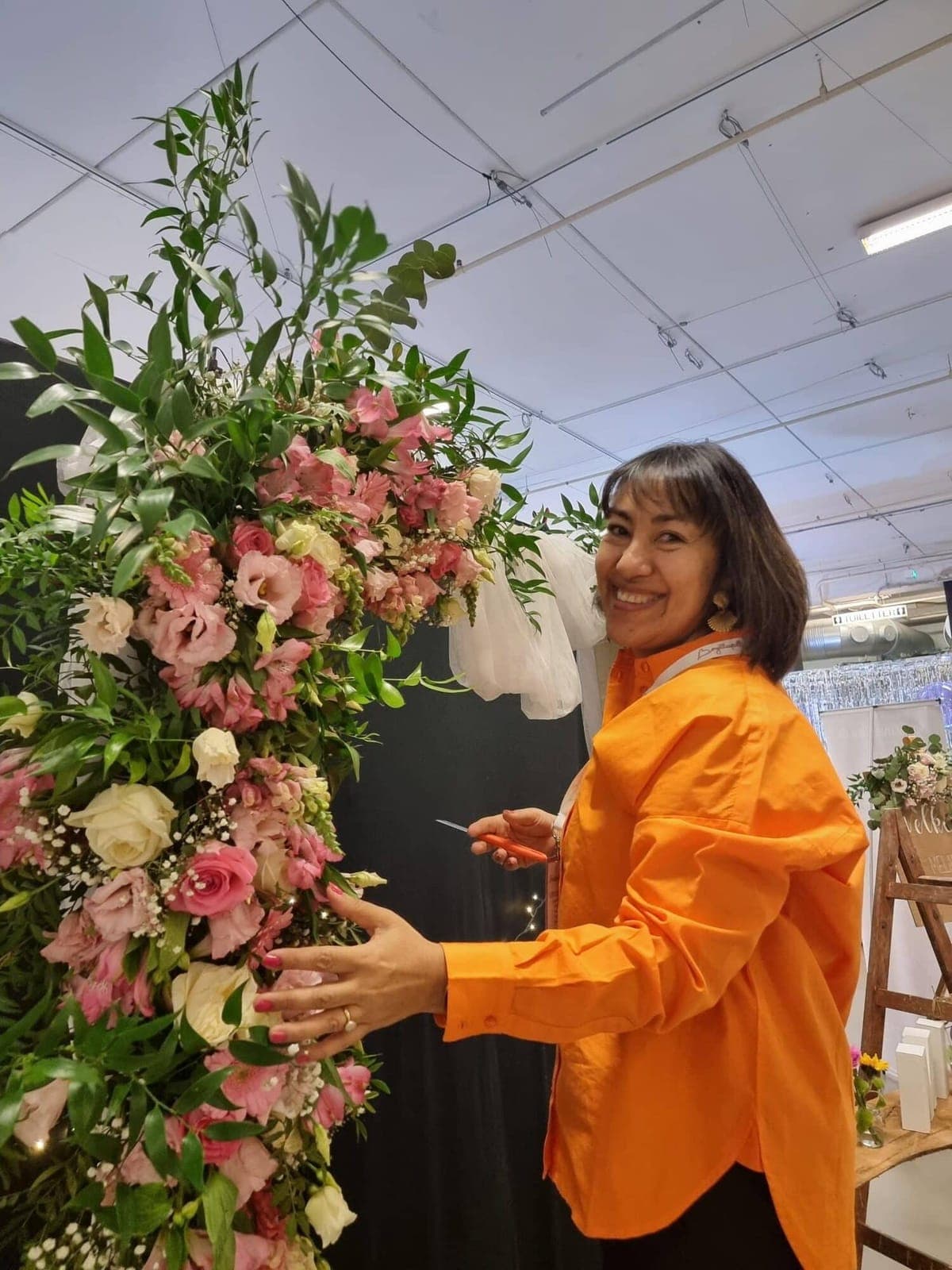 Lissette Jensen, florist, arbejder på en blomsterbue med lyserøde roser